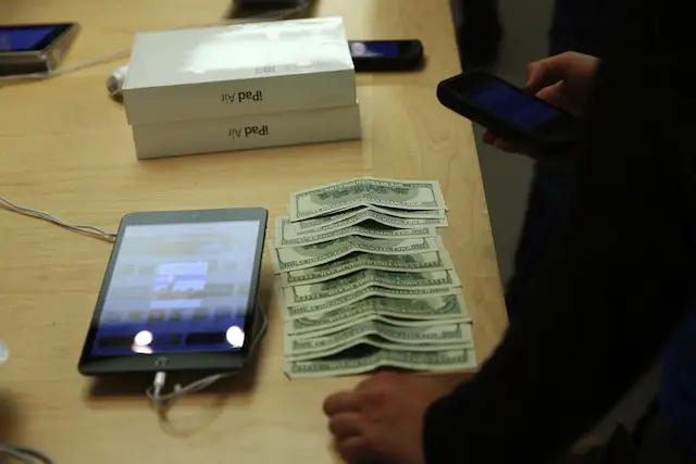A customer pays in cash for the new iPad Air